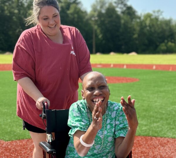 Camp Kamassa camper in wheelchair enjoying the baseball field