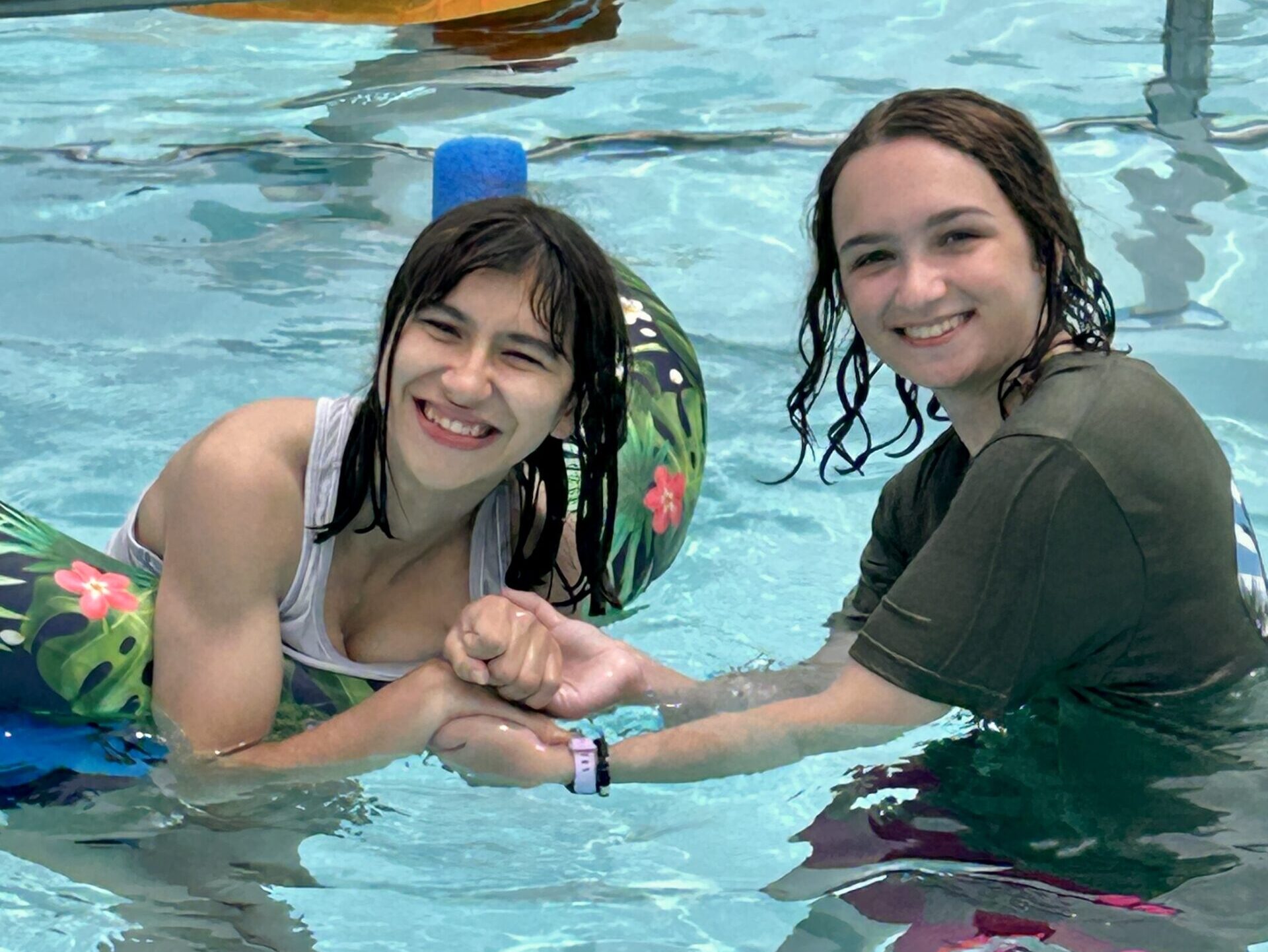 Kamassa summer staff assisting camper in the pool