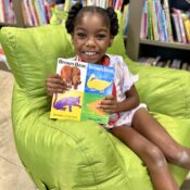 Kamassa camper holding a book in the library.