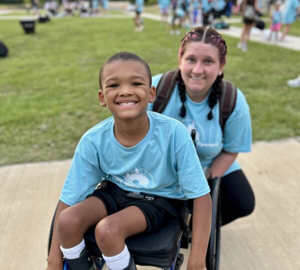 Camper in wheelchair with volunteer at Camp Kamassa