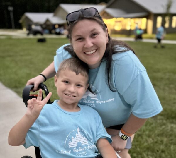 Camper in wheelchair with volunteer at Camp Kamassa