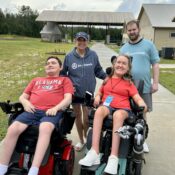 Campers in wheelchairs with group leader during check-in at Camp Kamassa.