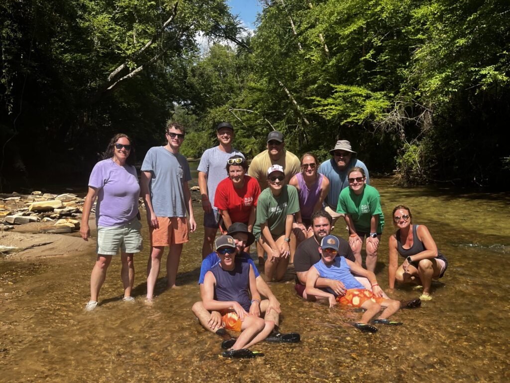 Campers and volunteers in creek at Camp Kamassa