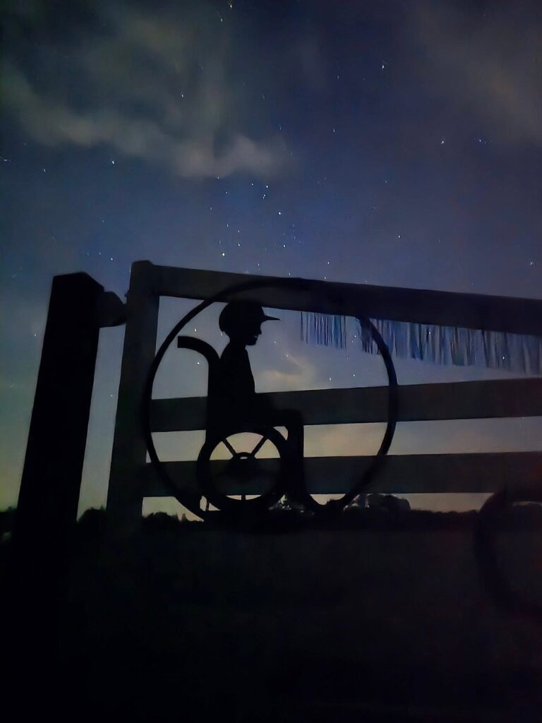 Camp Kamassa gate with emblem of a boy sitting in a wheelchair.