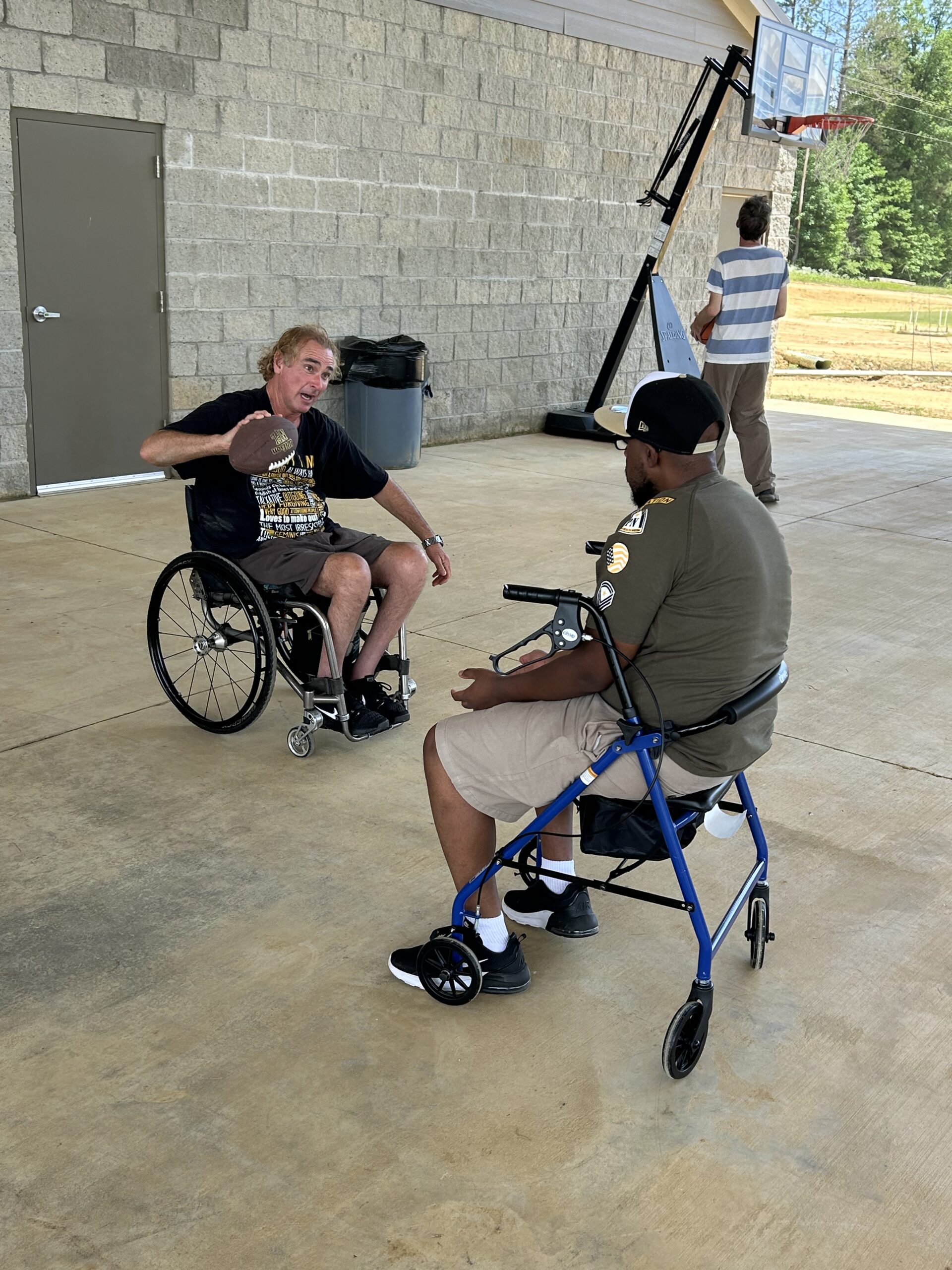 Campers using wheelchairs play ball under the pavilion at Camp Kamassa.