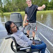 Camper fishing from accessible pier at Camp Kamassa.