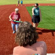 Camper running relay on baseball field at Camp Kamassa.
