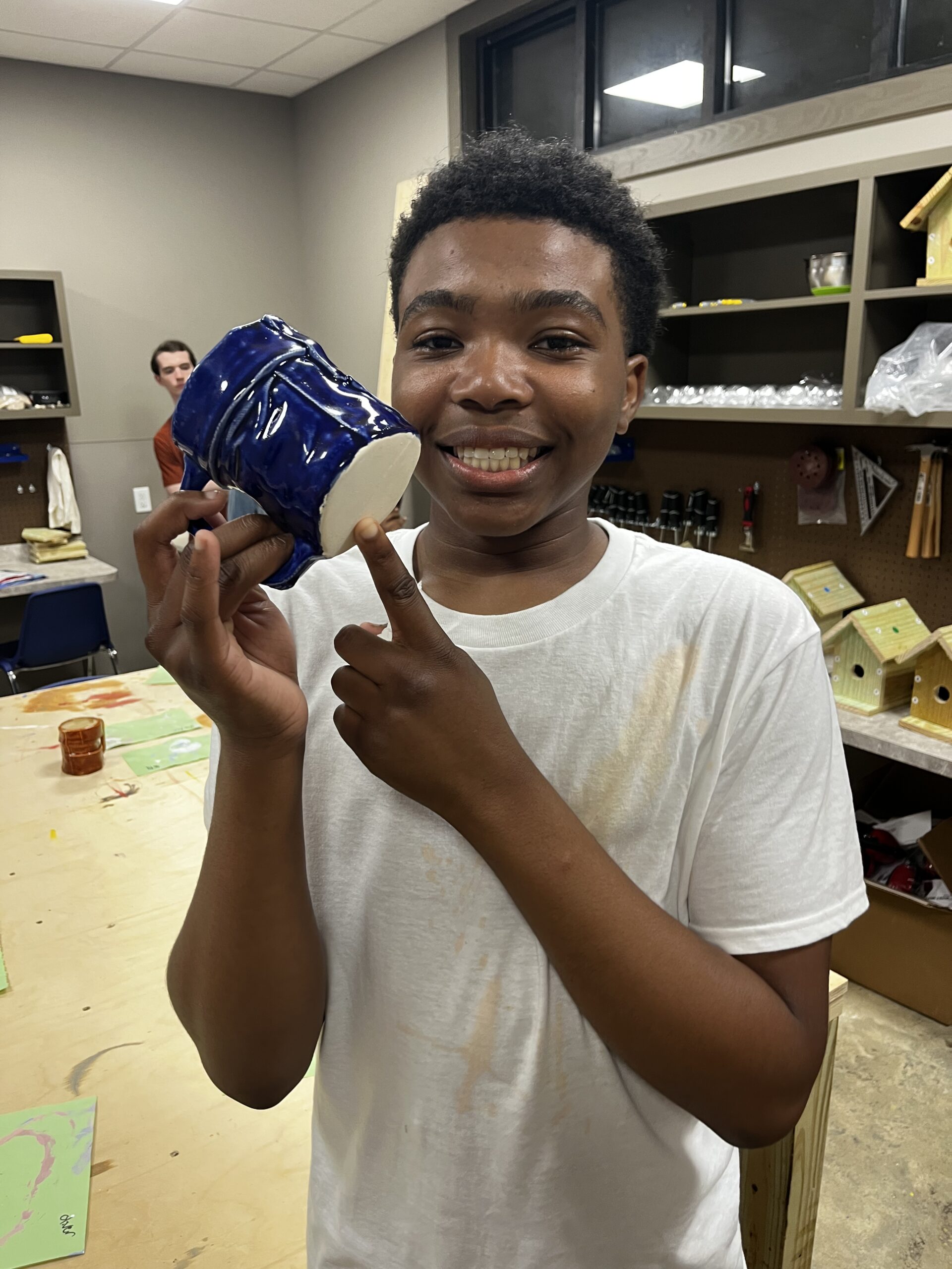 Camper showing ceramics project at Camp Kamassa.